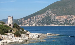 Küste von Kefalonia mit einem Turm der Venezianischen Burg Agios Georgios im Hintergrund