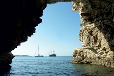 Blick von einer Höhle im Meer auf das offene Meer, auf dem zwei Schiffe zu sehen sind