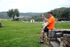 Ein Radler sitzt in Istrien auf einem Steinmäuerchen und genießt einen wohlverdienten guten Tropfen.
