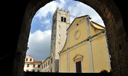 Die Kirche von Motovun durch einen Torbogen betrachtet.