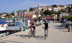 Zwei Radfahrer im Hafen von Vrsar.