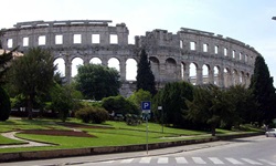Das von Bäumen eingerahmte, weltbekannte Amphitheater von Pula.