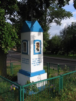 Eine von einem grünen Metallzaun umgebene, blau-weiße Kapelle am Radweg von Swinemünde nach Danzig.