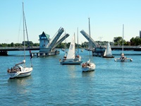 Boote im Hafen verlassen über die geöffnete Klappbrücke den Hafen in Kappeln