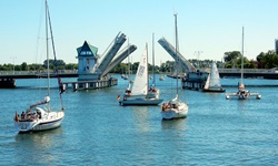 Boote im Hafen verlassen über die geöffnete Klappbrücke den Hafen in Kappeln