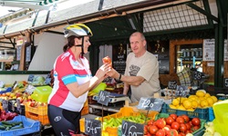 Eine Radlerin kauft ungarisches Paprikagewürz an einem Marktstand.