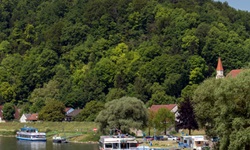 Blick auf angelegte Schiffe auf der Donau bei Kelheim mit Blick zur hoch thronenden Befreiungshalle