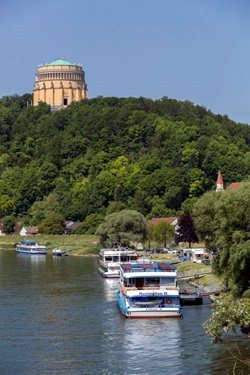 Blick auf angelegte Schiffe auf der Donau bei Kelheim mit Blick zur hoch thronenden Befreiungshalle