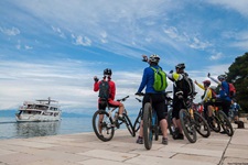 Eine Gruppe Mountainbiker winkt der Andela Lora zu, die sie soeben in einem Hafen der Kvarner Bucht abgesetzt hat und jetzt zum Ziel der heutigen Tagesetappe fährt, um die Gäste dort wieder aufzunehmen.