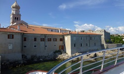 Blick auf den Kirchturm und die Rückseite von Häusern der Stadt Krk in der Kvarner Bucht von Kroatien vom Schiff aus gesehen