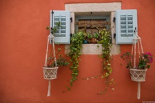 Ein Fenster mit schönem Blumenschmuck in einem alten Dorf.