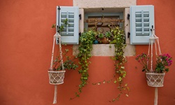 Ein Fenster mit schönem Blumenschmuck in einem alten Dorf.