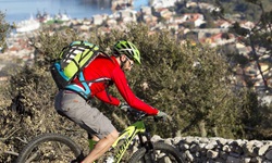 Ein Mountainbiker mti roter Jacke fährt einen felsigen Trail in Kroatien hinab