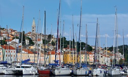 Blick auf die angelegten Boote und Schiffe mit der bunten Hafenpromenade von Mali Losinj auf der Insel Losinj in der Kvarner Bucht Kroatiens