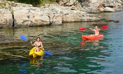 Zwei Personen in zwei Kayaks paddeln im Meer