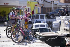 Vier Mountainbiker - zwei Frauen und zwei Männer - gönnen sich im Hafen eine kleine Erfrischung, ehe sie sich wieder an Bord ihres Schiffes begeben.