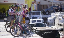 Vier Radler - zwei Männer und zwei Frauen - haben ihre Mountainbikes im Hafen von Cres abgestellt und gönnen sich eine kleine Erfrischung.