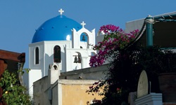 Eine weiße Kirche mit blauem Dach, wie sie für die Region der Kykladen typisch ist.