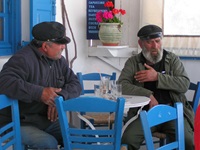 Einheimische auf den Kykladen sitzen in einem Café und unterhalten sich