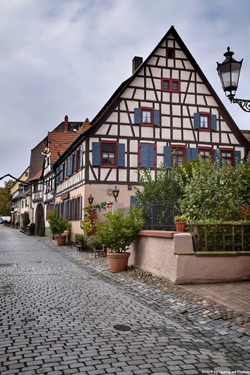 Fachwerkhäuser in einer kopfsteingepflasterten Gasse in Ladenburg.