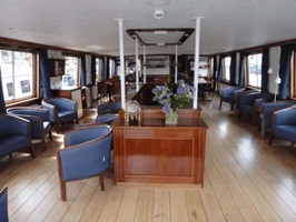 Blick in den schön eingerichteten Salon mit blau bezogenen Sesseln der MS Lena Maria