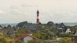 Blick auf einen rot-weißen Leuchtturm auf der Radstrecke von Hamburg nach Sylt