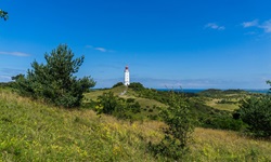Der Leuchtturm Dornbusch - das Wahrzeichen der Insel Hiddensee - erhebt sich über die sanft hügelige, grasbewachsene Landschaft.