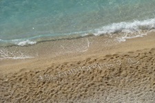 Strand an der Lykischen Küste in der Türkei - mit Steinen wurde das Wort "ISLANDHOPPING" und ein Segelboot gelegt
