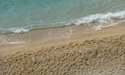 Strand an der Lykischen Küste in der Türkei - mit Steinen wurde das Wort "ISLANDHOPPING" und ein Segelboot gelegt