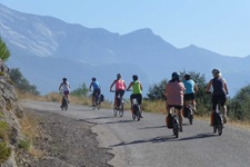 Eine große Radlergruppe fährt eine steile Straße hinauf