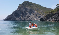 Ein Motorschlauchboot fährt mit Touristen auf dem Meer an der Lykischen Küste entlang