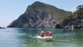 Ein Motorschlauchboot fährt mit Touristen auf dem Meer an der Lykischen Küste entlang