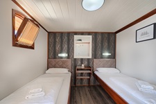 Blick in eine Zwei-Bett-Kabine mit einem zu öffnenden Fenster auf dem Deluxe Schiff Magellan