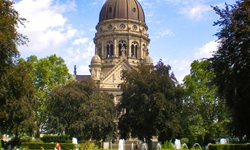 Der Turm der Evangelischen Christuskirche in Mainz überragt einen kleinen Park.