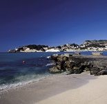 Blick auf einen schönen Sandstrand auf Mallorca mit Blick zu einer Stadt