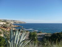 Blick auf einen kleinen Sandstrand mit felsigen Abschnitten in einer Bucht auf Mallorca