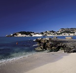 Sandstrand auf Mallorca mit Blick zu einer Stadt auf der Insel