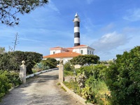 Blick auf den schwar-weißen Leuchtturm in Portocolom auf Mallorca