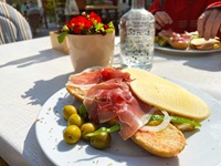 Reich gefüllter Teller mit Broten, Käse, Oliven und Schinken