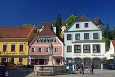 Der Meggaubrunnen dominiert den von bunten Häusern umringten Marktplatz von Grein.