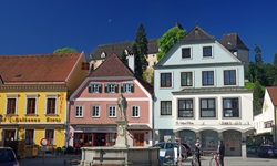 Der Meggaubrunnen dominiert den von bunten Häusern umringten Marktplatz von Grein.