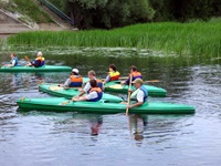 Vier grüne, jeweils mit zwei Personen besetzte Paddelboote auf dem Flusslauf der Kruttinna.