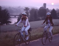 Zwei Frauen radeln auf der Schweizer Mittellandroute im Sonnenuntergang ihrem nächsten Übernachtungsquartier entgegen.