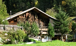 Blick auf ein typisches Bauernhaus mit viel Holzgeräten an der Hauswand im Mölltal