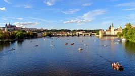 Blick über die Moldau, die von einigen Tretbooten befahren wird, bis zur Karlsbrücke in Prag