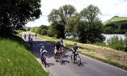 Eine Familie mit mehreren Kindern radelt auf dem Mosel-Radweg.