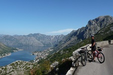 Ein Radfahrer macht Pause auf einer Straße und blickt zur Bucht von Kotor in Montenegro hinab
