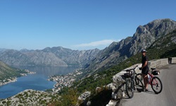 Ein Radfahrer macht Pause auf einer Straße und blickt zur Bucht von Kotor in Montenegro hinab