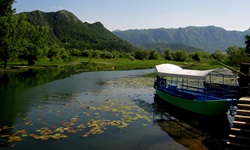 Blick auf den Skutarisee mit einem leeren Ausflugsboot