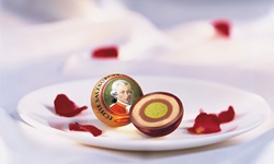 Zwei appetitlich auf einem Teller angerichtete Mozartkugeln.
